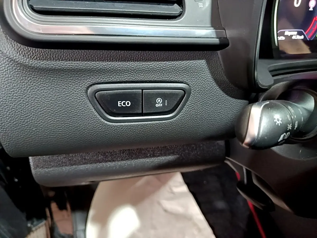 Gros plan sur les boutons ECO et arrêt auto start du tableau de bord noir du Renault Kadjar Intens 2018.