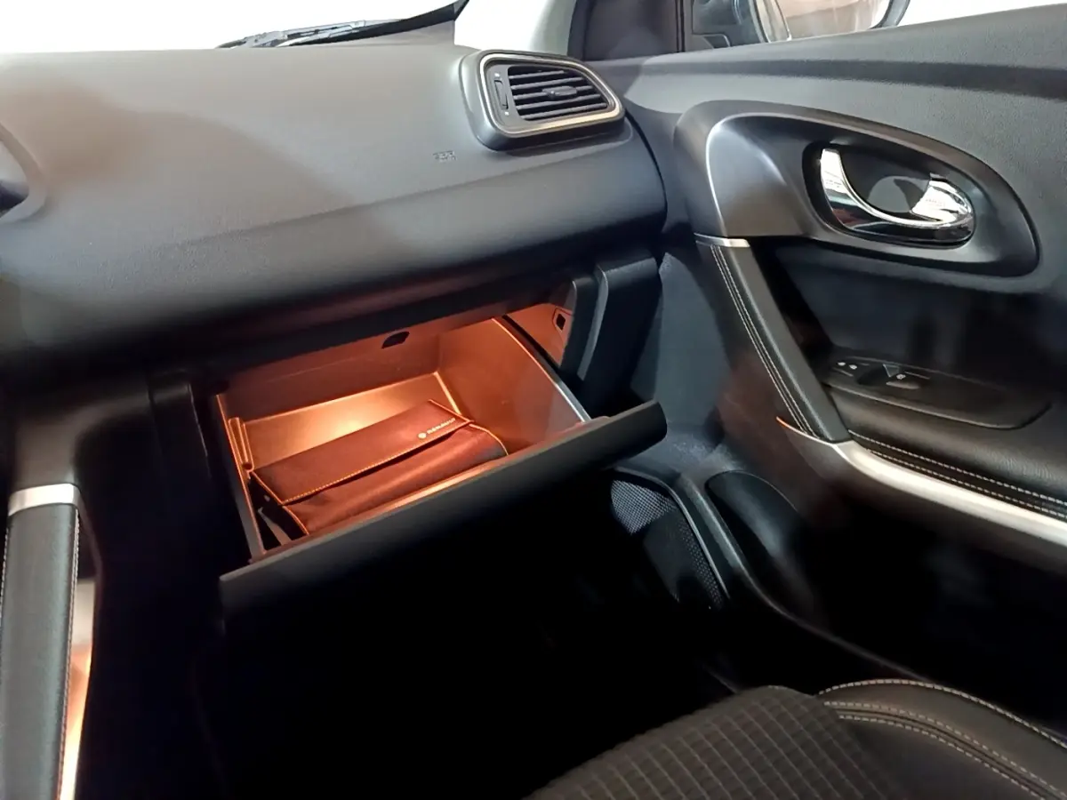 Intérieur côté passager du Renault Kadjar Intens 2018, boîte à gants ouverte avec éclairage intérieur orange.