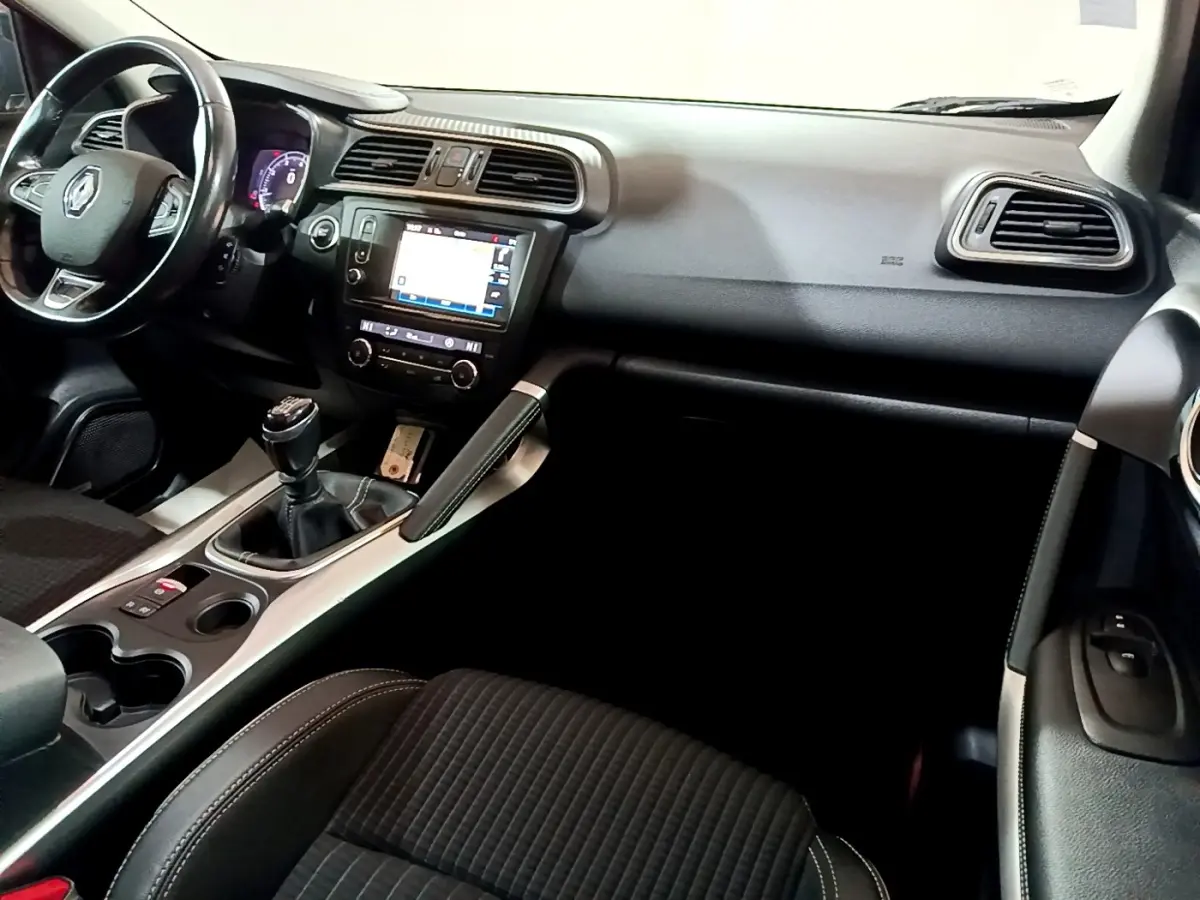 Intérieur Renault Kadjar Intens 2018 vu côté passager, tableau de bord noir avec écran tactile et volant cuir.