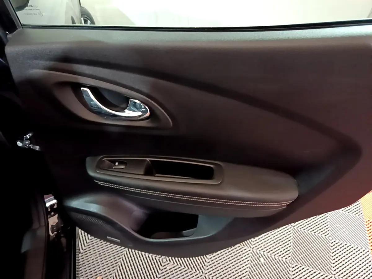 Panneau intérieur noir côté gauche de la porte avant Renault Kadjar Intens 2018 avec poignée chromée et commande de vitre.