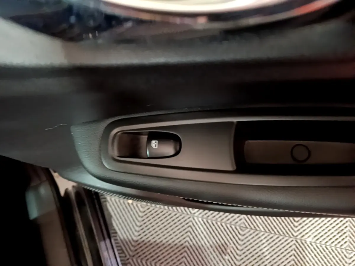 Gros plan sur le bouton de verrouillage des portes côté gauche dans l'habitacle noir du Renault Kadjar Intens 2018.