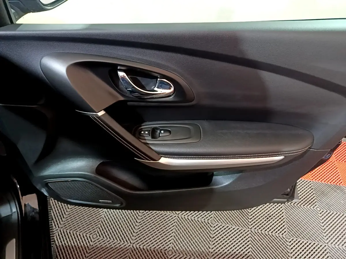 Porte intérieure côté gauche noire du Renault Kadjar Intens 2018 avec poignée chromée et commandes de vitres.