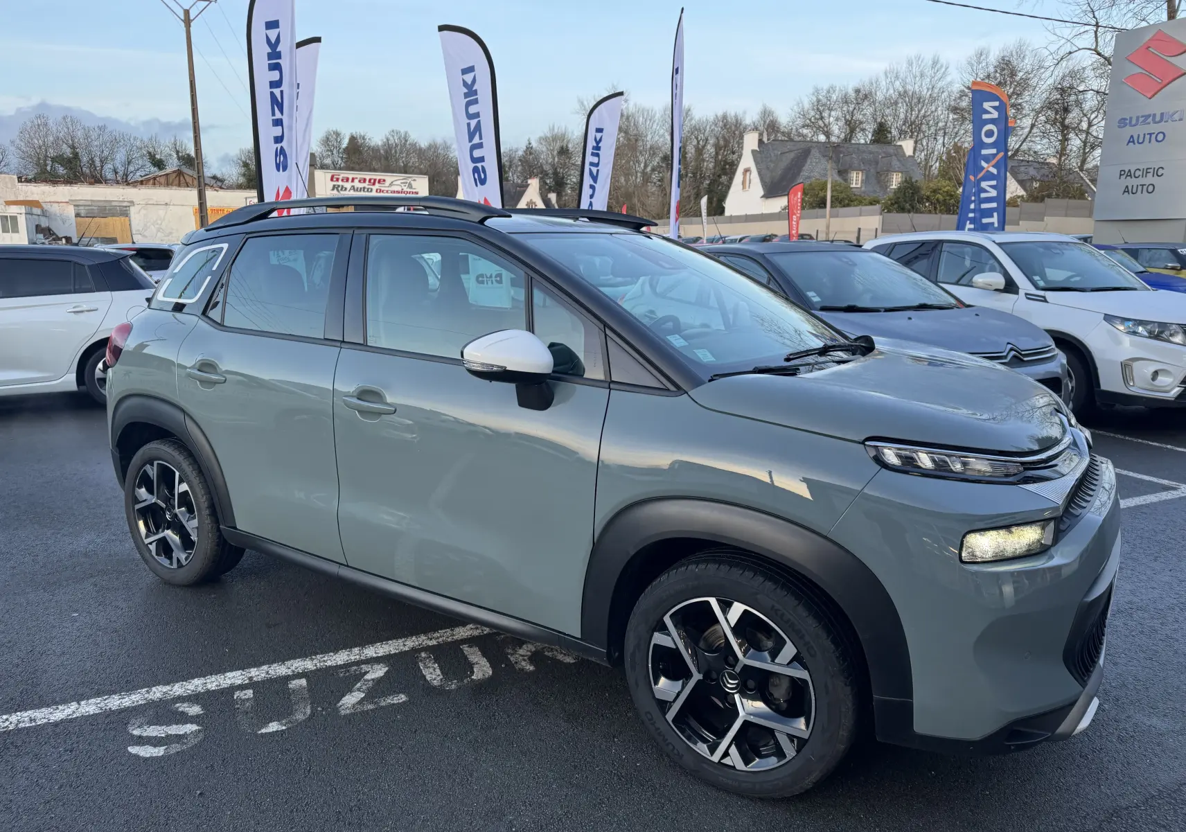 Suzuki Swace bleu 2025 en 3/4 avant droit, avec calandre noire et jantes argentées en showroom.
