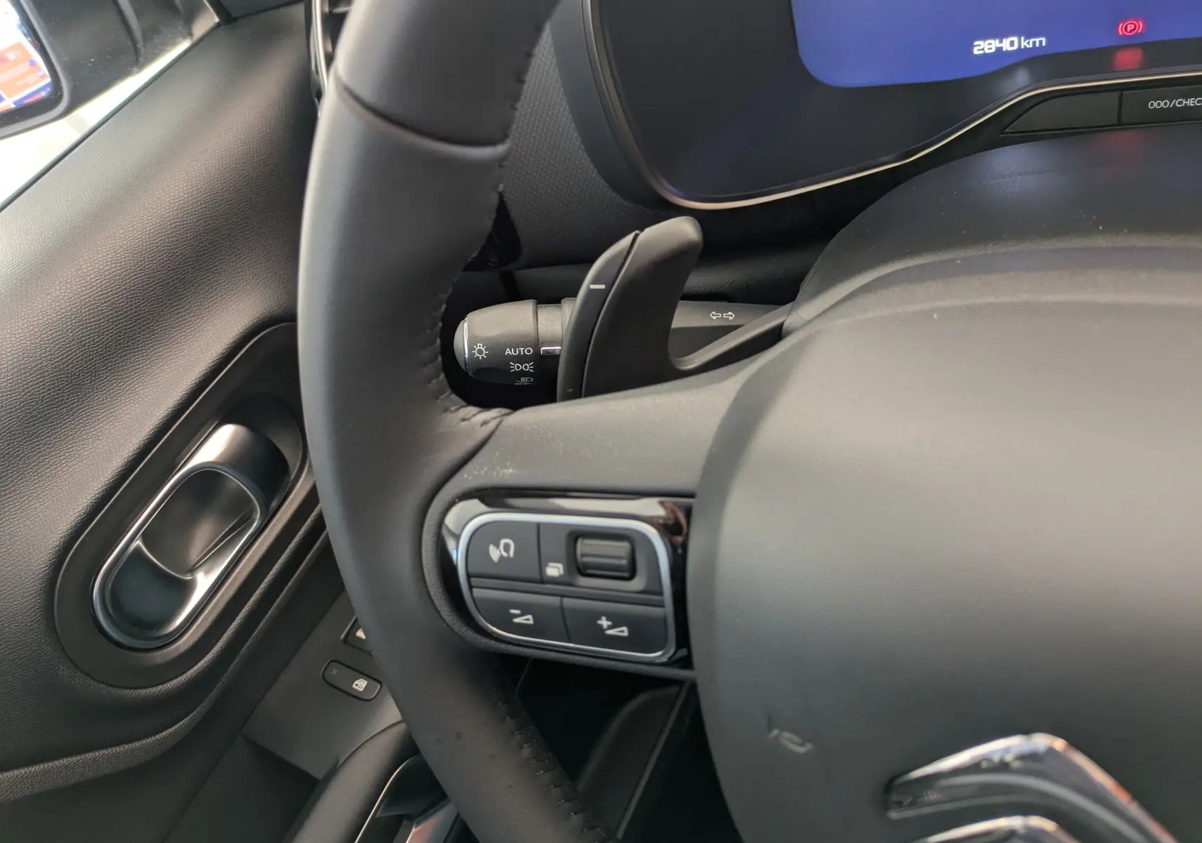 Gros plan sur le volant en cuir noir et la commande multifonction côté gauche du tableau de bord d'un Citroën C5 Aircross 2025.