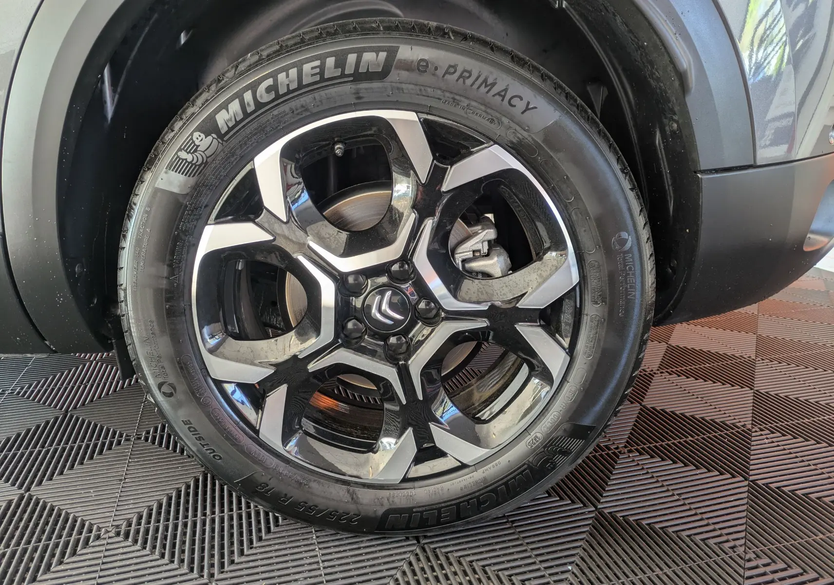 Gros plan sur la roue avant droite d'un Citroën C5 Aircross gris platinium, avec jante alliage 18 pouces biton visible.