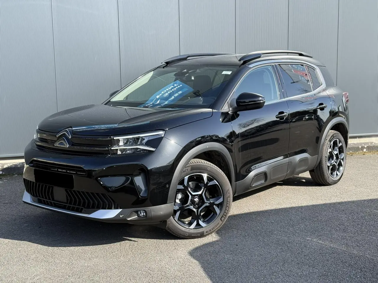 Citroën C5 Aircross noir Perla vue 3/4 avant droit avec jantes alliage bi-ton et barres de toit noires.
