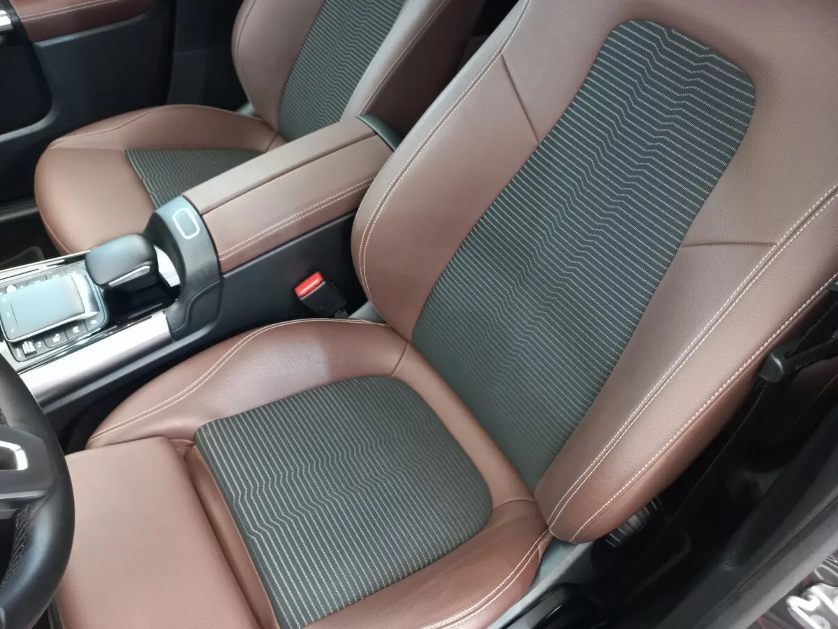 Gros plan intérieur sur les sièges avant marron et noir du Mercedes GLA 200 Business Line 2021, avec console centrale visible.