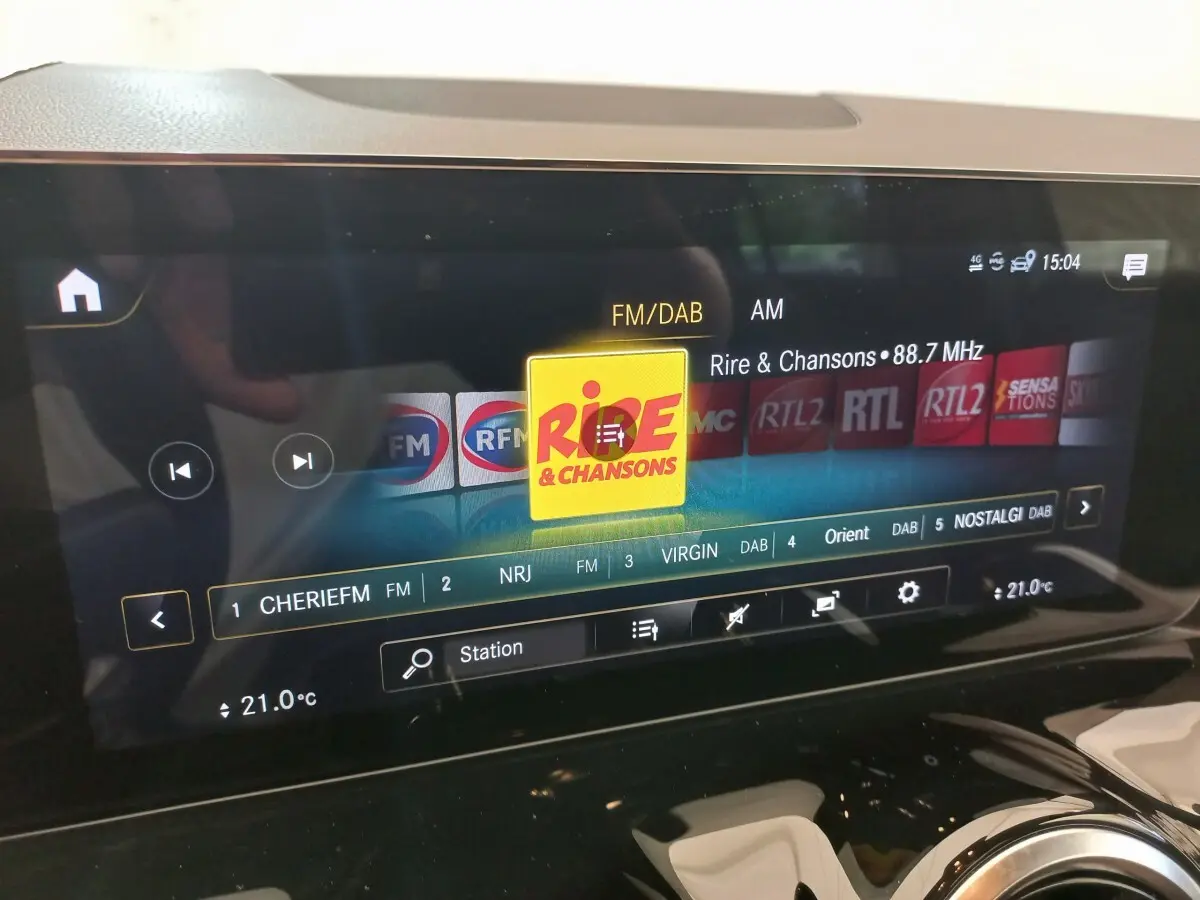 Écran tactile central du tableau de bord d’une Mercedes GLA 200 Business Line gris foncé, affichant les radios FM/DAB.