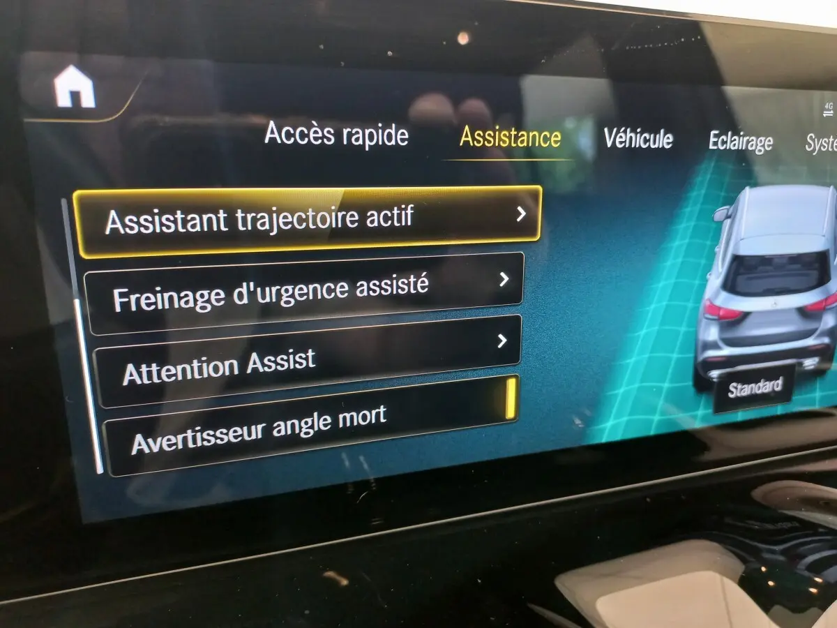 Écran tactile intérieur montrant les options d'assistance avec une vue arrière 3D d'un Mercedes GLA gris foncé.