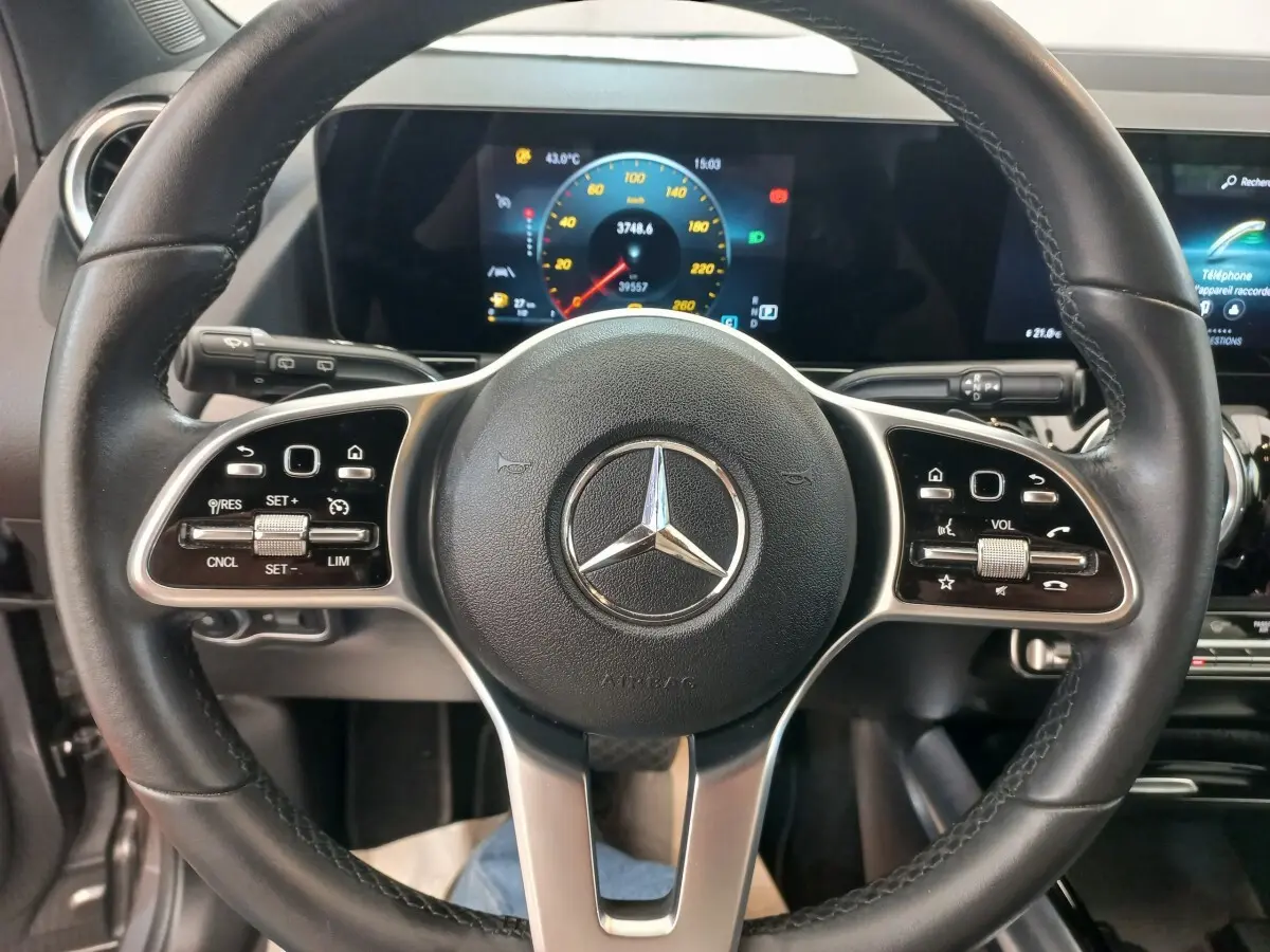 Vue rapprochée du volant cuir noir d’une Mercedes GLA 200 Business Line 2021 avec tableau de bord numérique coloré.