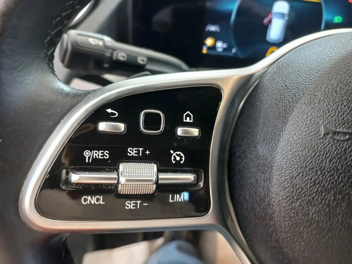 Gros plan sur les commandes au volant cuir noir du Mercedes GLA 200 Business Line 2021, avec boutons multifonctions.