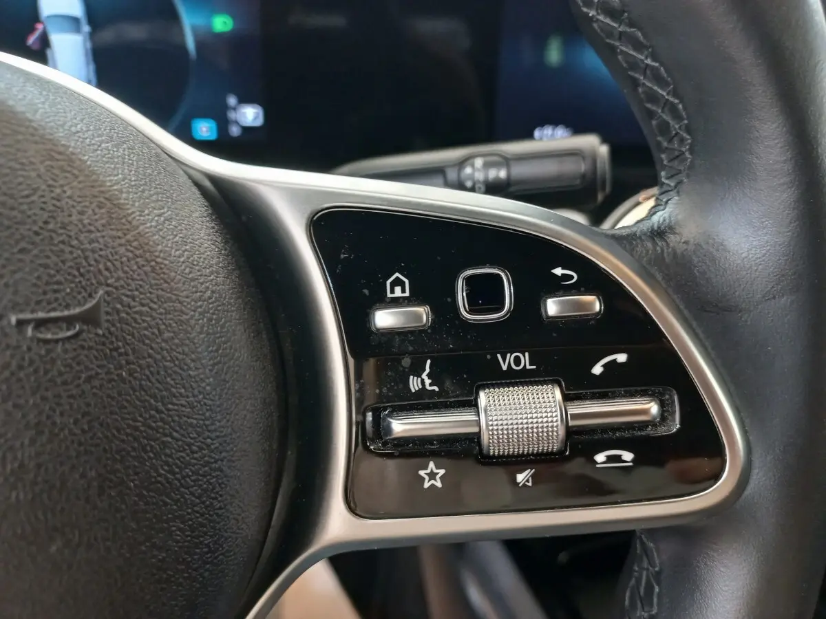Gros plan sur les commandes multifonctions du volant cuir à droite du Mercedes GLA 200 Business Line gris foncé, 2021.