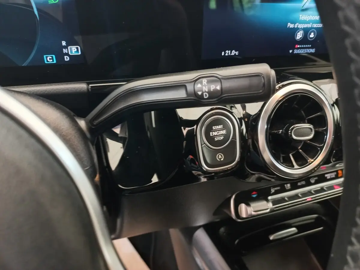 Gros plan sur le tableau de bord noir du Mercedes GLA 200, avec bouton start/stop et commande de boîte automatique.