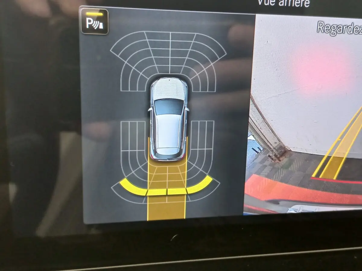 Affichage intérieur de la caméra de recul et capteurs de stationnement du Mercedes GLA 200 gris foncé en vue aérienne.