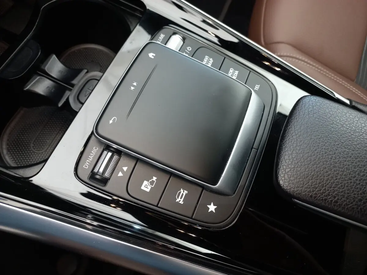 Gros plan sur la console centrale noire brillante du Mercedes GLA 200 Business Line 2021 avec pavé tactile et commandes.