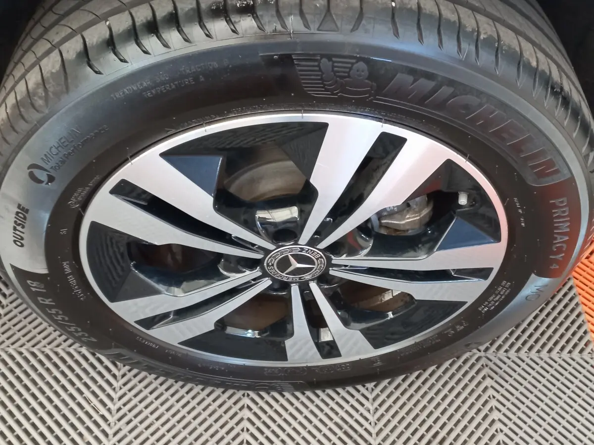 Gros plan sur la jante alliage bicolore noir et argent avec logo Mercedes d’une Mercedes GLA gris foncé.