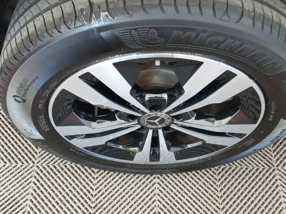Gros plan sur la jante alliage bicolore noire et argentée d'un Mercedes GLA gris foncé, pneu Michelin visible.