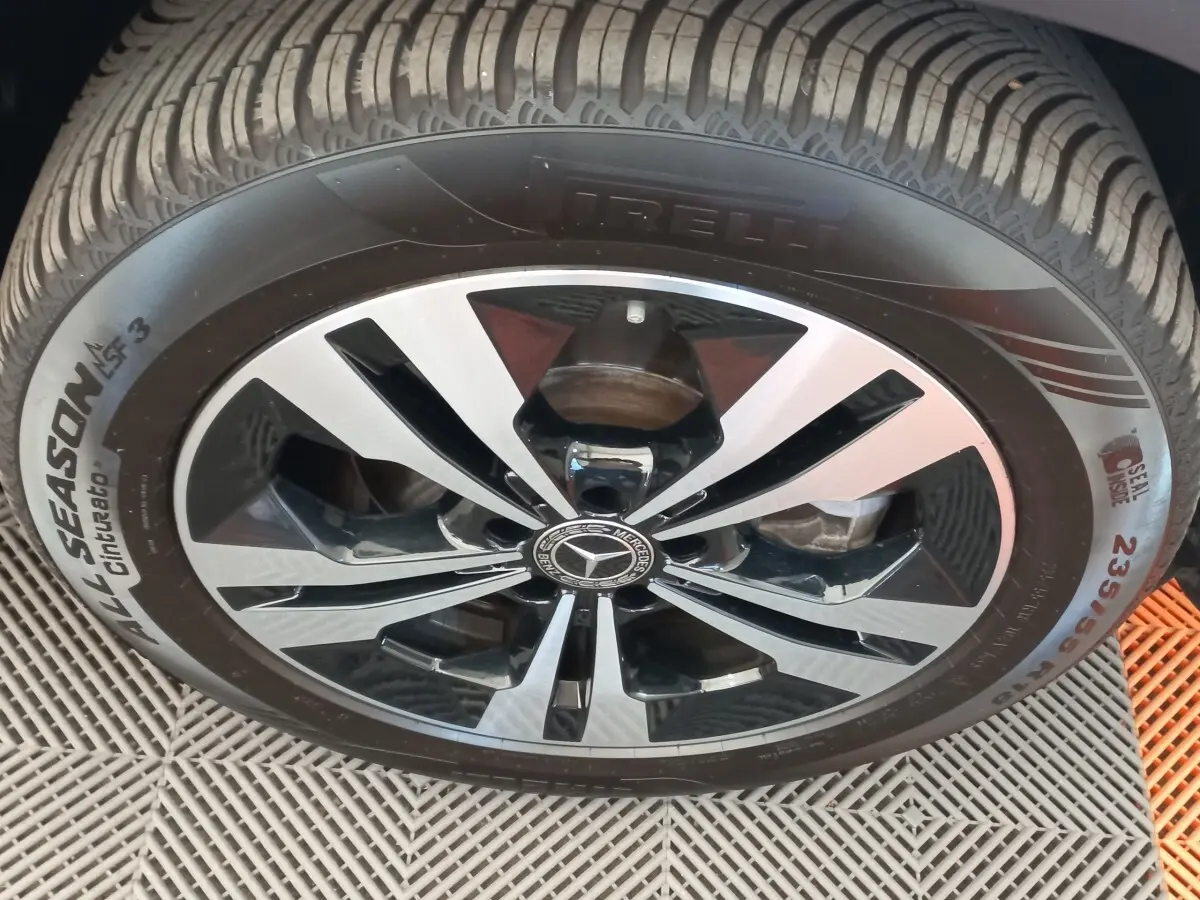 Gros plan sur la roue avant avec jante alliage bicolore noir et argent du Mercedes GLA gris foncé 2021.