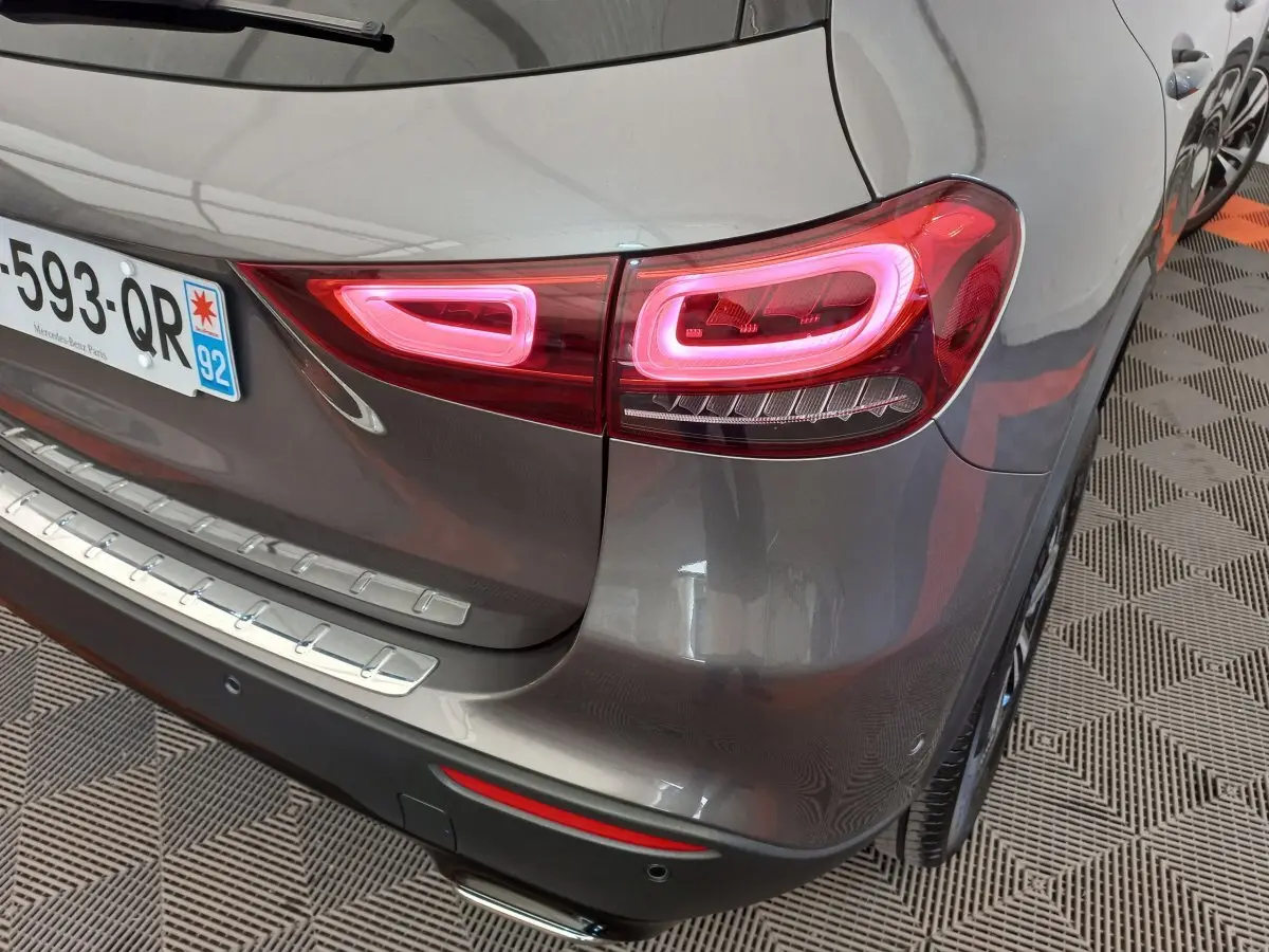 Feu arrière droit allumé d’un Mercedes GLA 200 Business Line gris foncé, vue en gros plan sur le coin arrière.