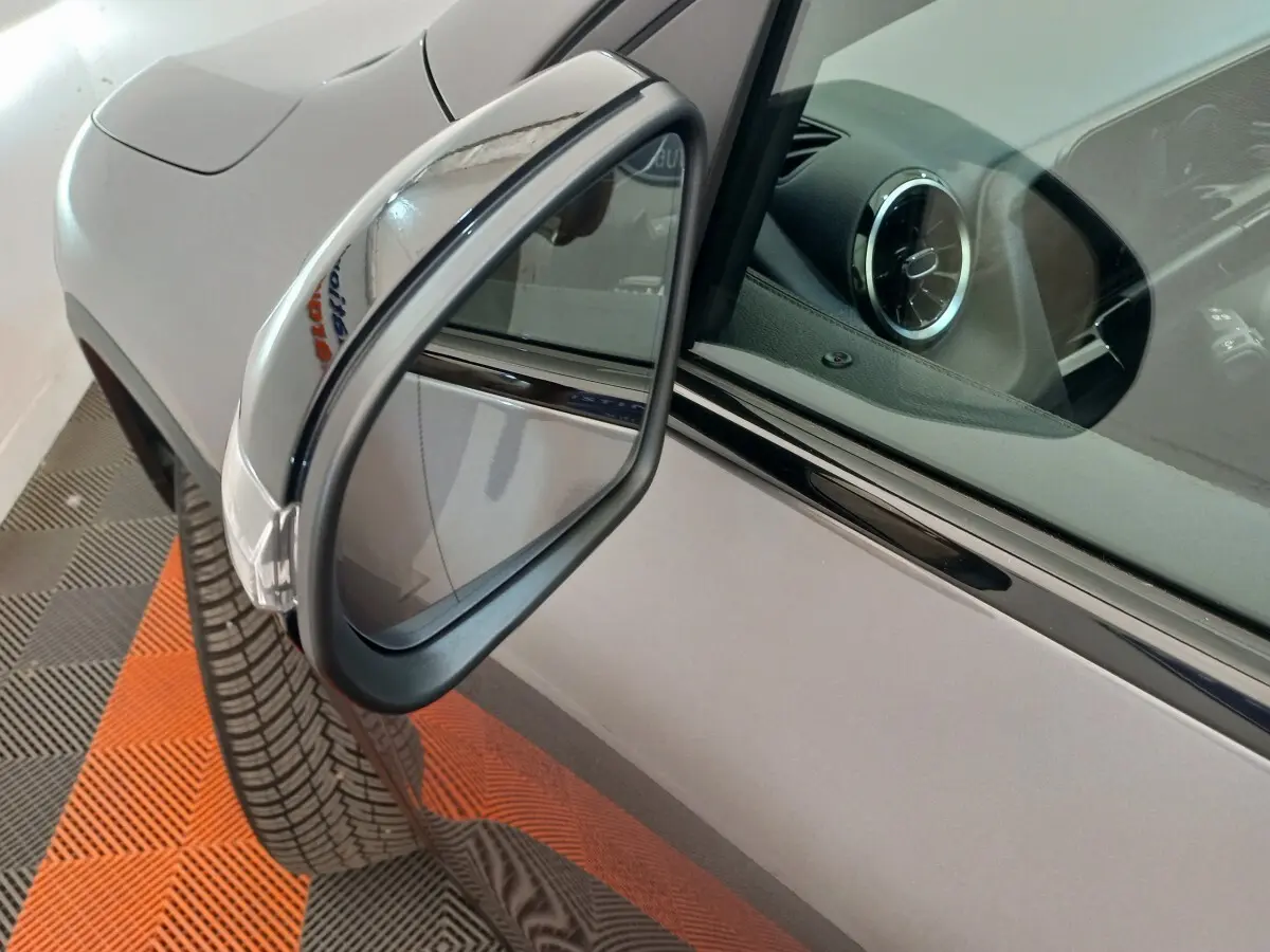 Rétroviseur côté gauche d’un Mercedes GLA 200 Business Line gris foncé avec partie avant et tableau de bord visible.