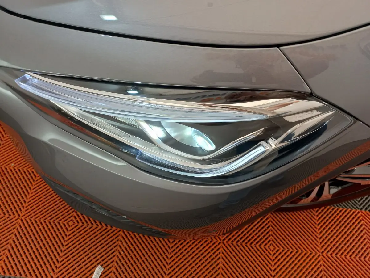 Gros plan sur le phare avant droit gris foncé d'une Mercedes GLA 200 Business Line 2021, détails LED visibles.