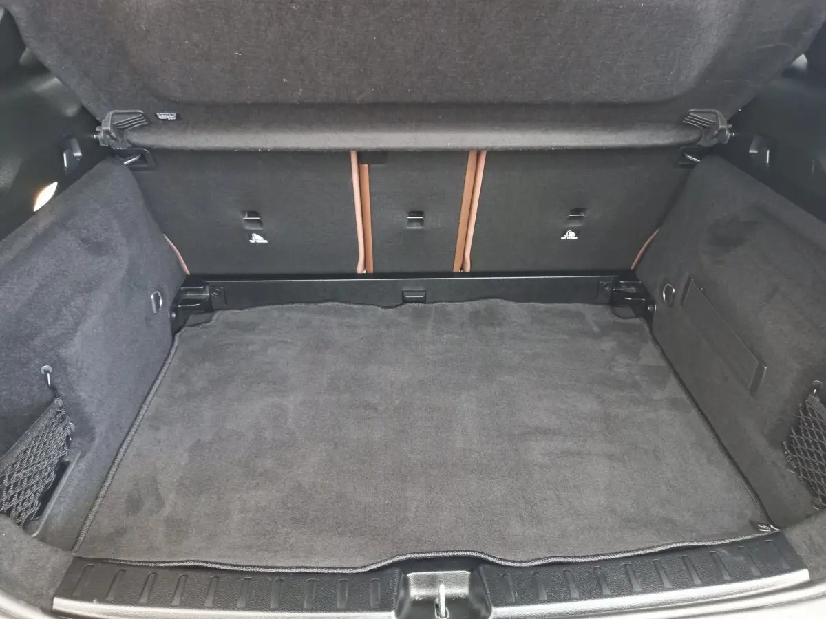 Coffre ouvert vu de face d’un Mercedes GLA 200 Business Line 2021, revêtement intérieur gris foncé avec filets latéraux.