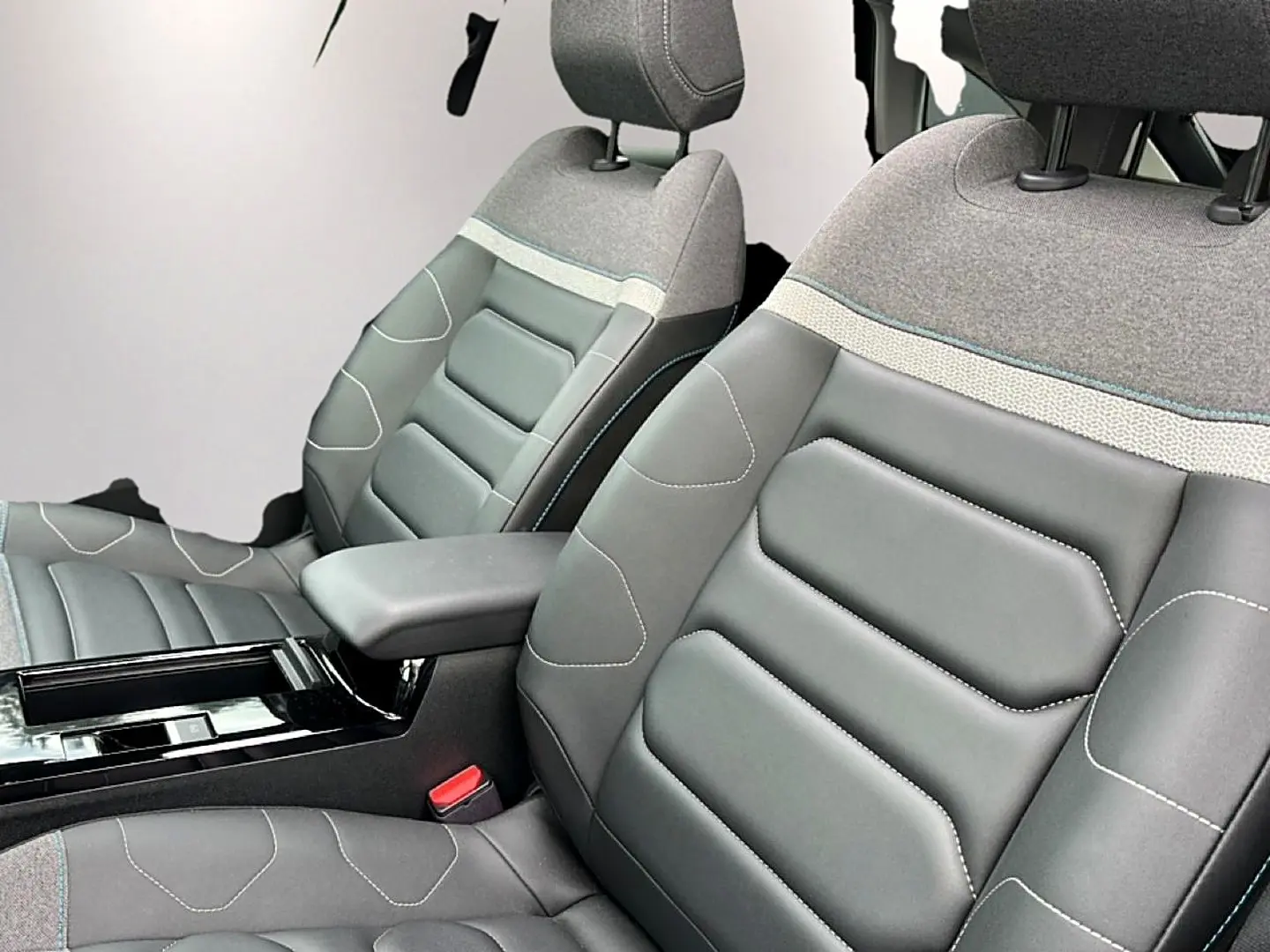 Gros plan sur les sièges avant gris bi-matière avec accoudoir central dans l'habitacle d'une Citroën C4 2024.