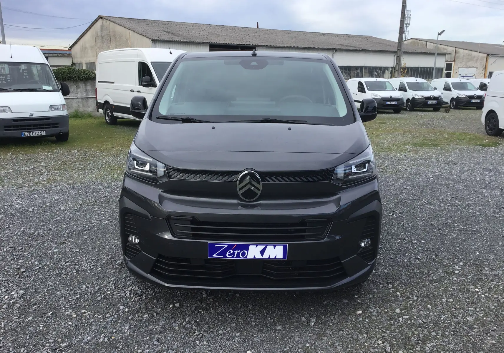 Vue de face d'un Citroën Jumpy Cabine Approfondie gris titane avec calandre noire et phares LED allumés.