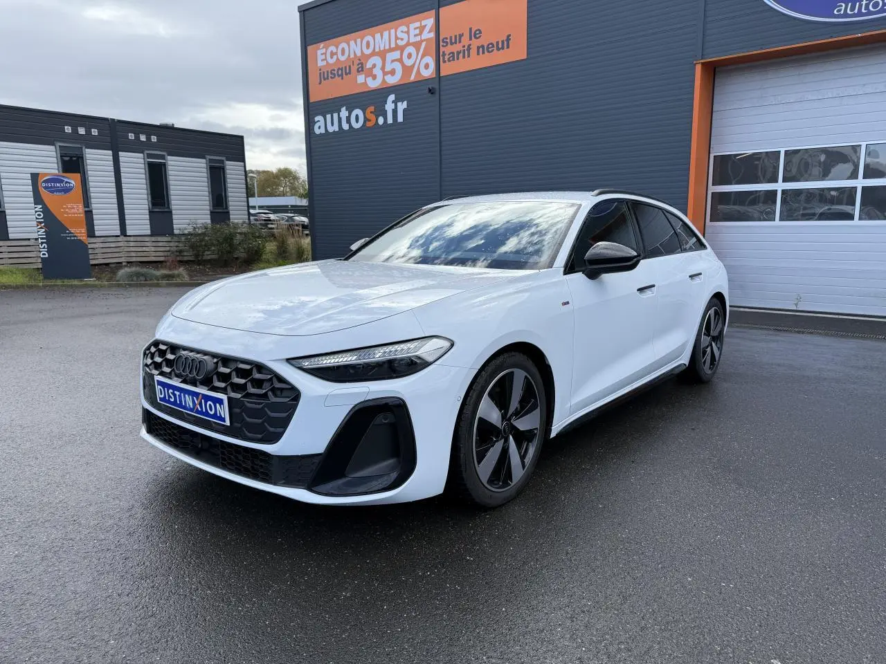 Audi A5 Avant blanc glacier métallisé vue 3/4 avant droit, avec calandre noire et jantes distinctives noires et argentées.