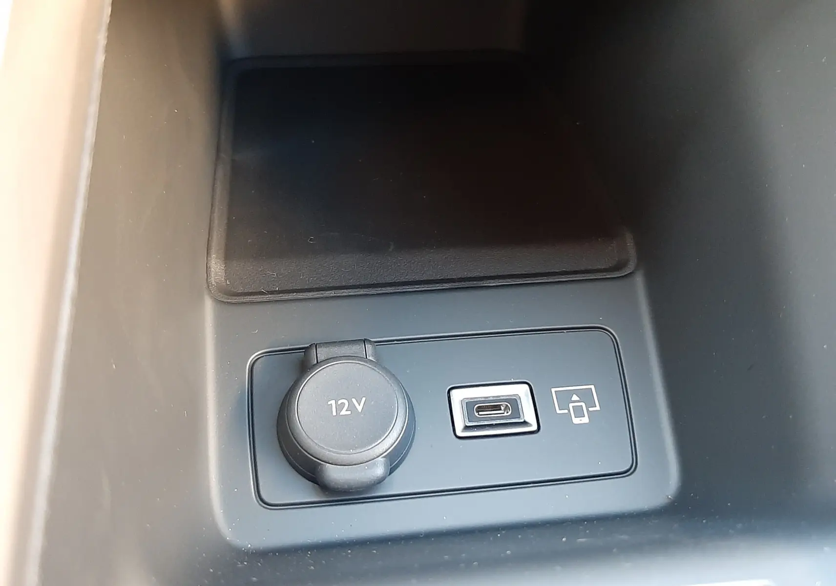 Prise 12V et port USB-C en gros plan dans la console centrale d'une Peugeot 308 Bleu Obsession 2025.