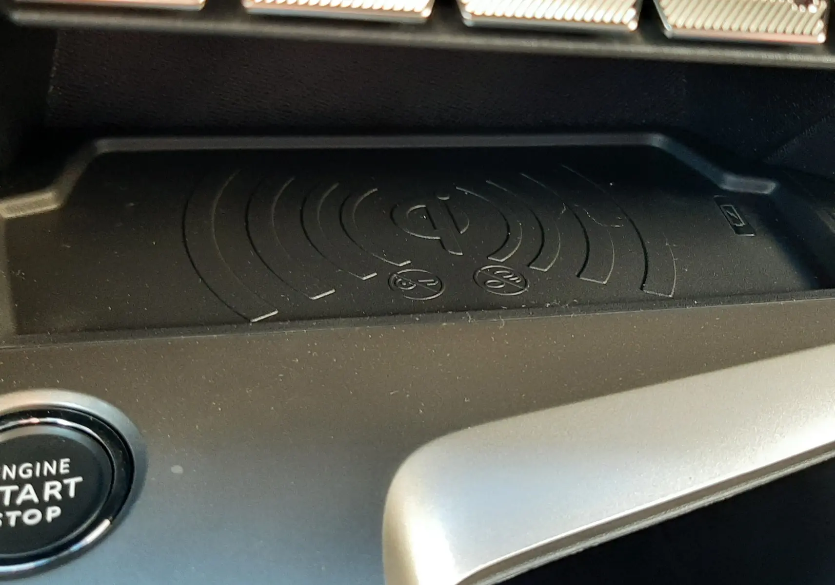 Gros plan sur la console centrale du Peugeot 308 Bleu Obsession 2025, montrant le chargeur à induction et les commandes tactiles.