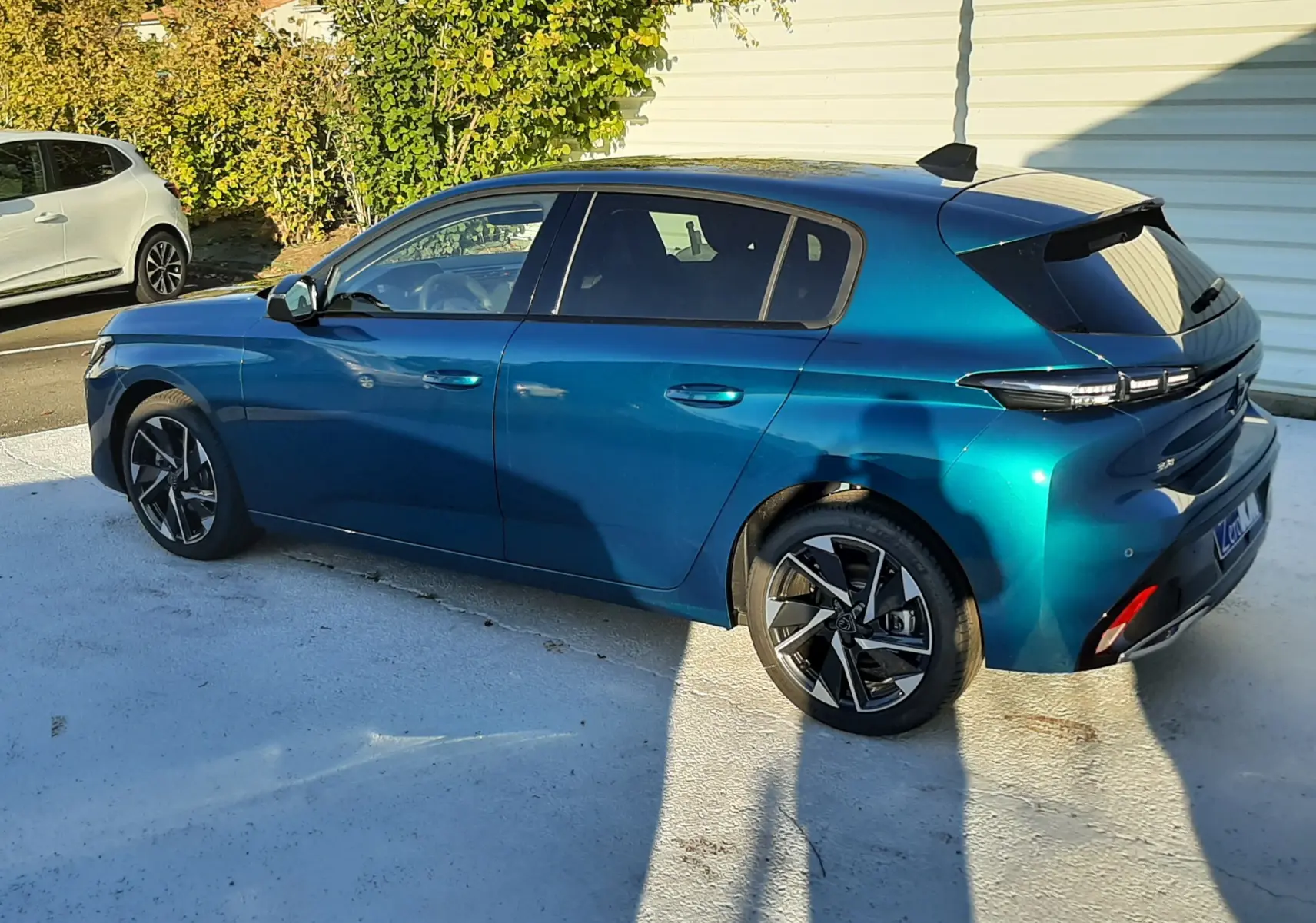 Peugeot 308 Bleu Obsession vue de côté droit arrière, soulignant ses jantes noires et son toit noir contrastant.