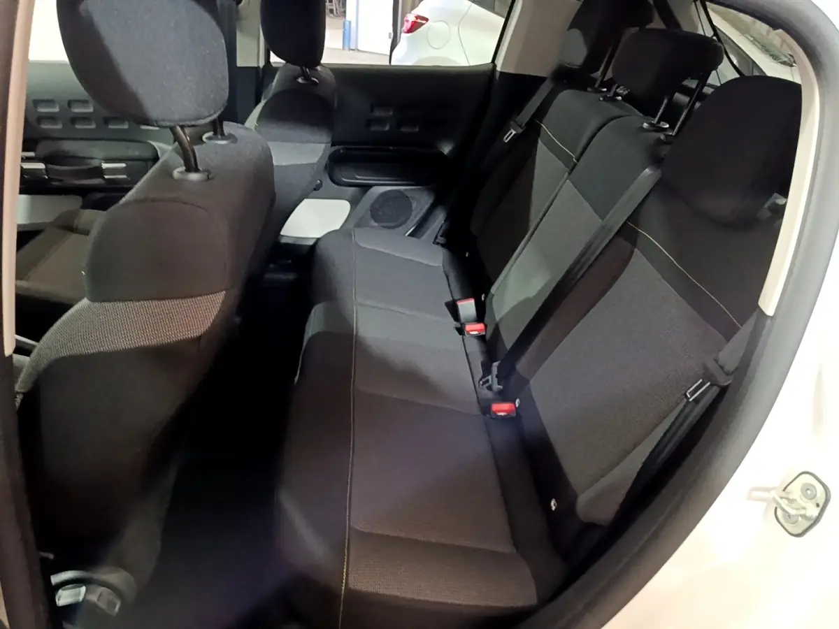 Vue intérieure côté droit montrant la banquette arrière noire de la Citroën C3 blanche 2023 PureTech Shine.