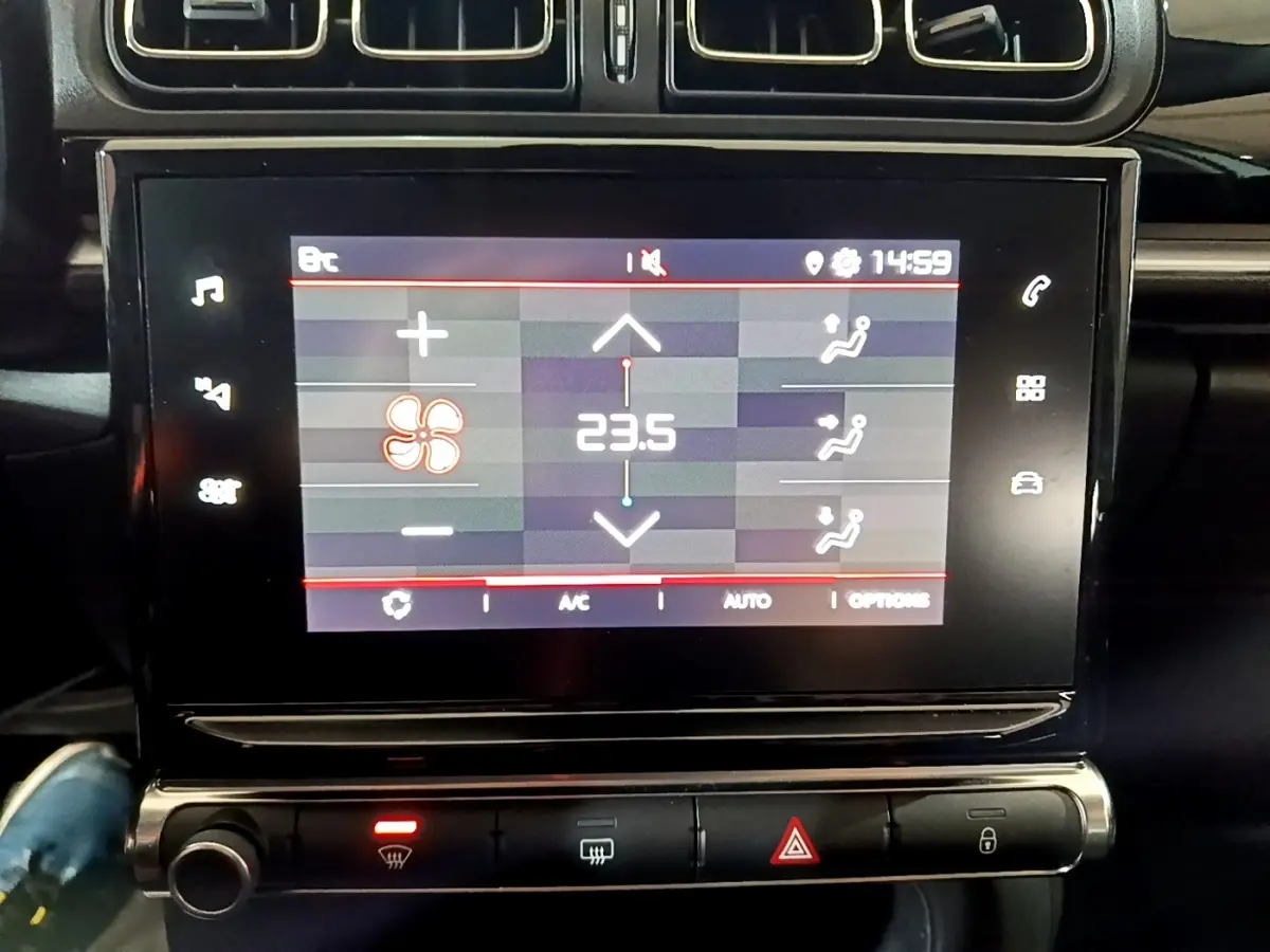 Écran tactile central affichant la climatisation à 23,5°C dans l'habitacle noir d'une Citroën C3 blanche 2023.