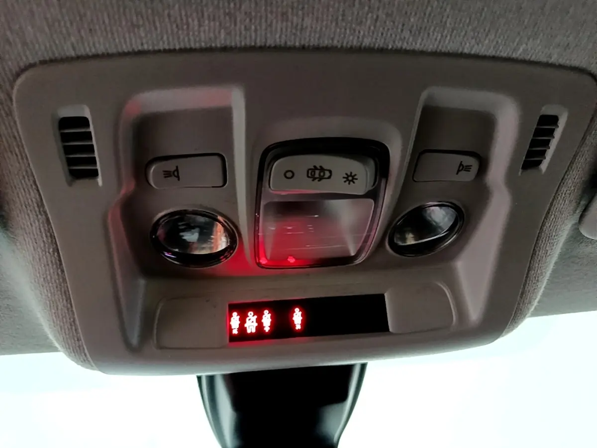 Vue en gros plan du plafonnier intérieur de la Citroën C3 blanche 2023 avec témoins de ceinture allumés.