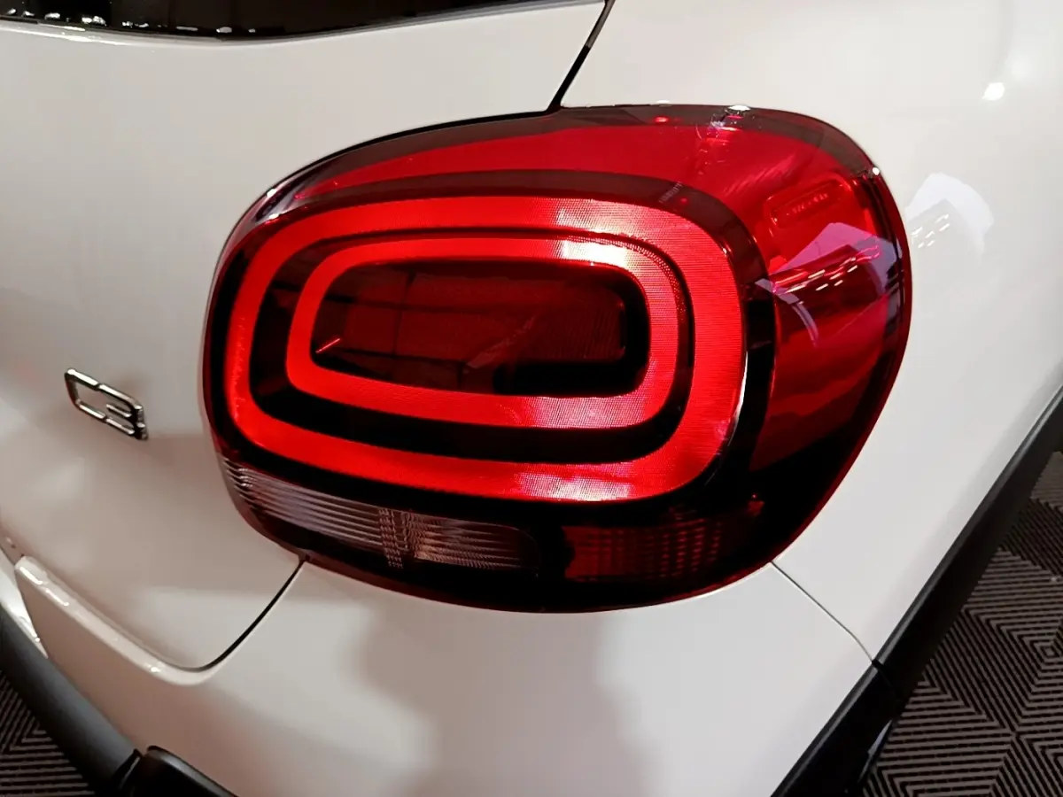 Gros plan sur le feu arrière droit rouge d'une Citroën C3 blanche 2023 avec logo C3 visible sur la carrosserie.