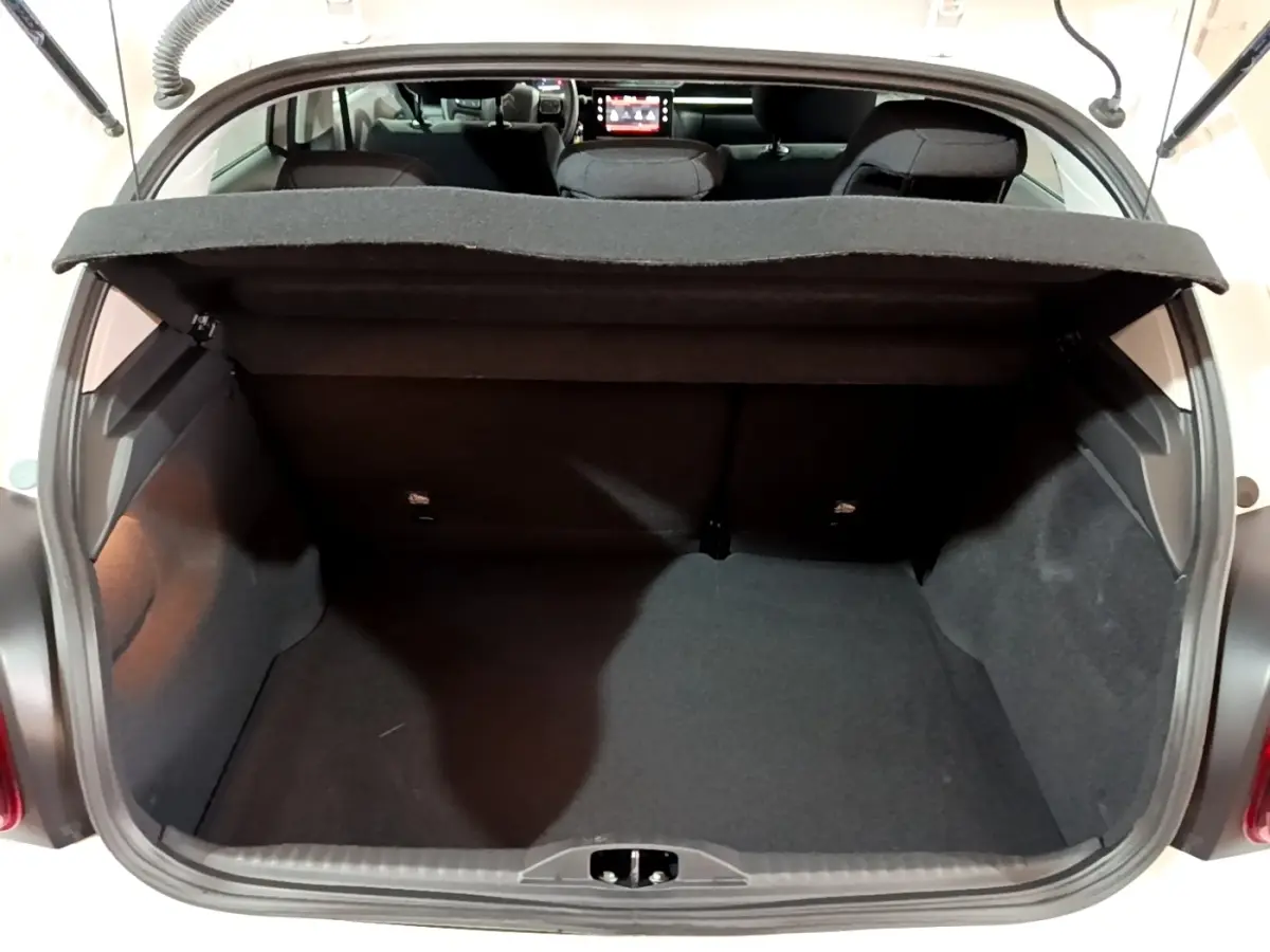 Coffre ouvert vu de l'arrière d'une Citroën C3 blanche 2023, montrant l'espace de chargement et banquette arrière.
