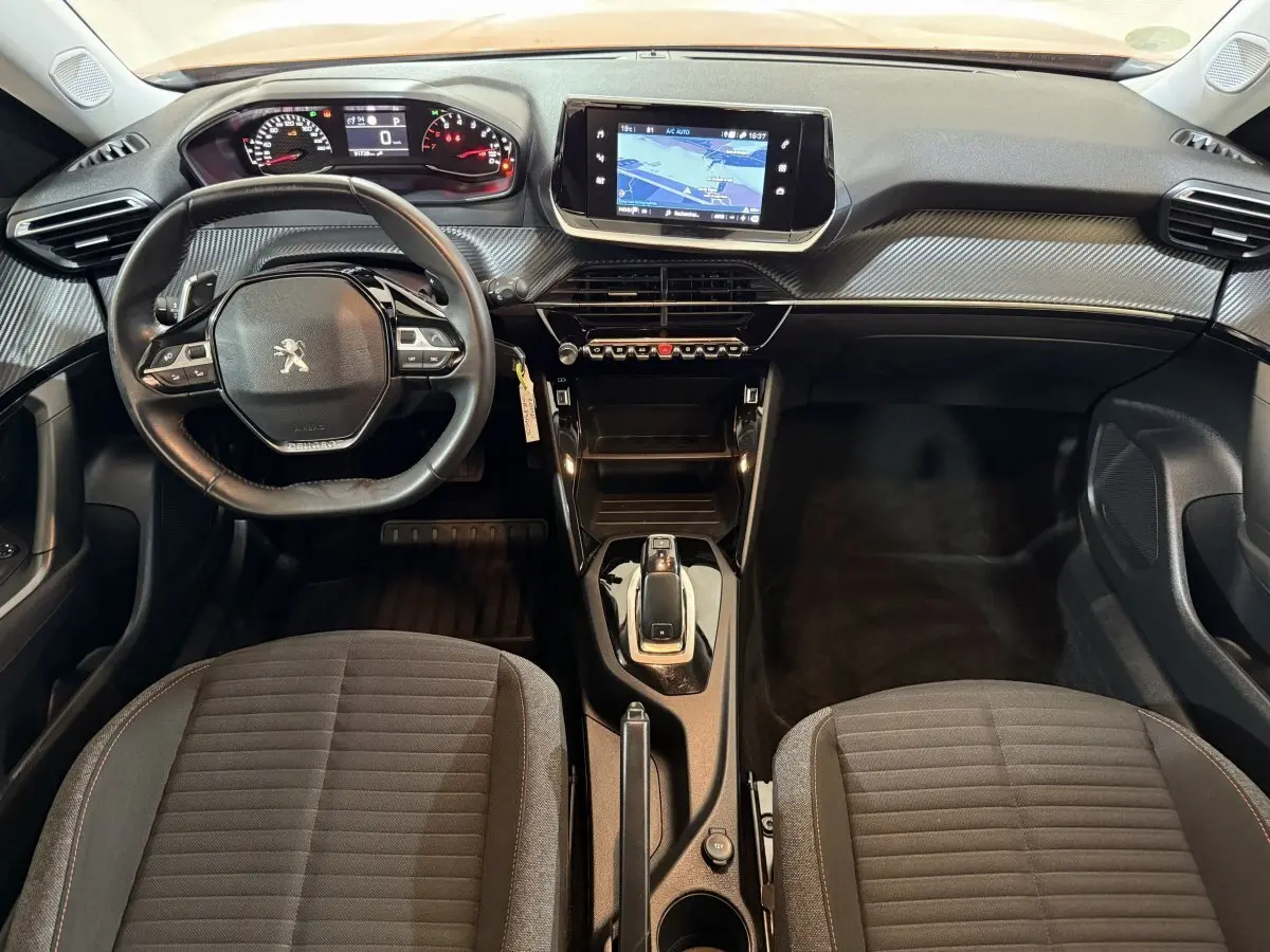 Vue intérieure avant du Peugeot 2008 2022, tableau de bord avec écran tactile central et volant cuir multifonctions noir.