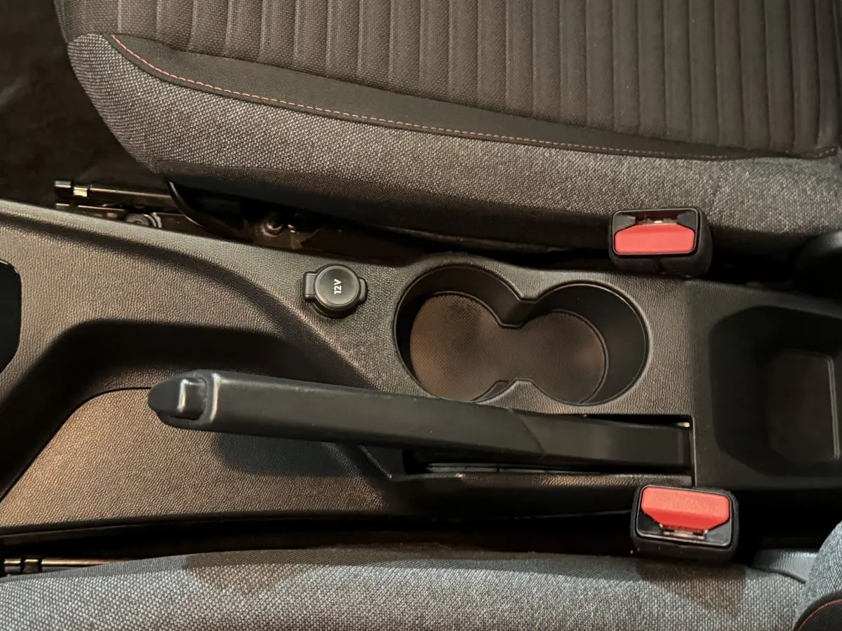 Vue rapprochée de la console centrale noire du Peugeot 2008 avec frein à main manuel et porte-gobelets.