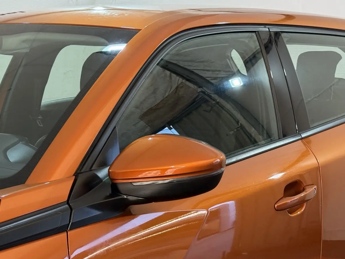 Vue rapprochée du rétroviseur côté gauche et de la porte orange d’un Peugeot 2008 2022 en finition Active Business.