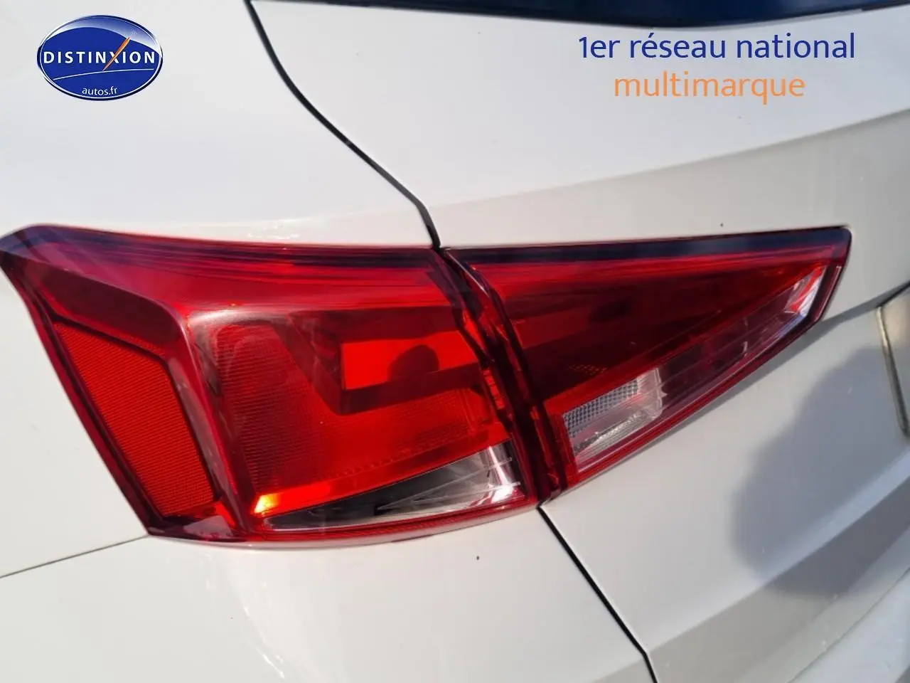 Gros plan sur le feu arrière droit rouge d’un SEAT Arona blanc, avec partie de la carrosserie visible.