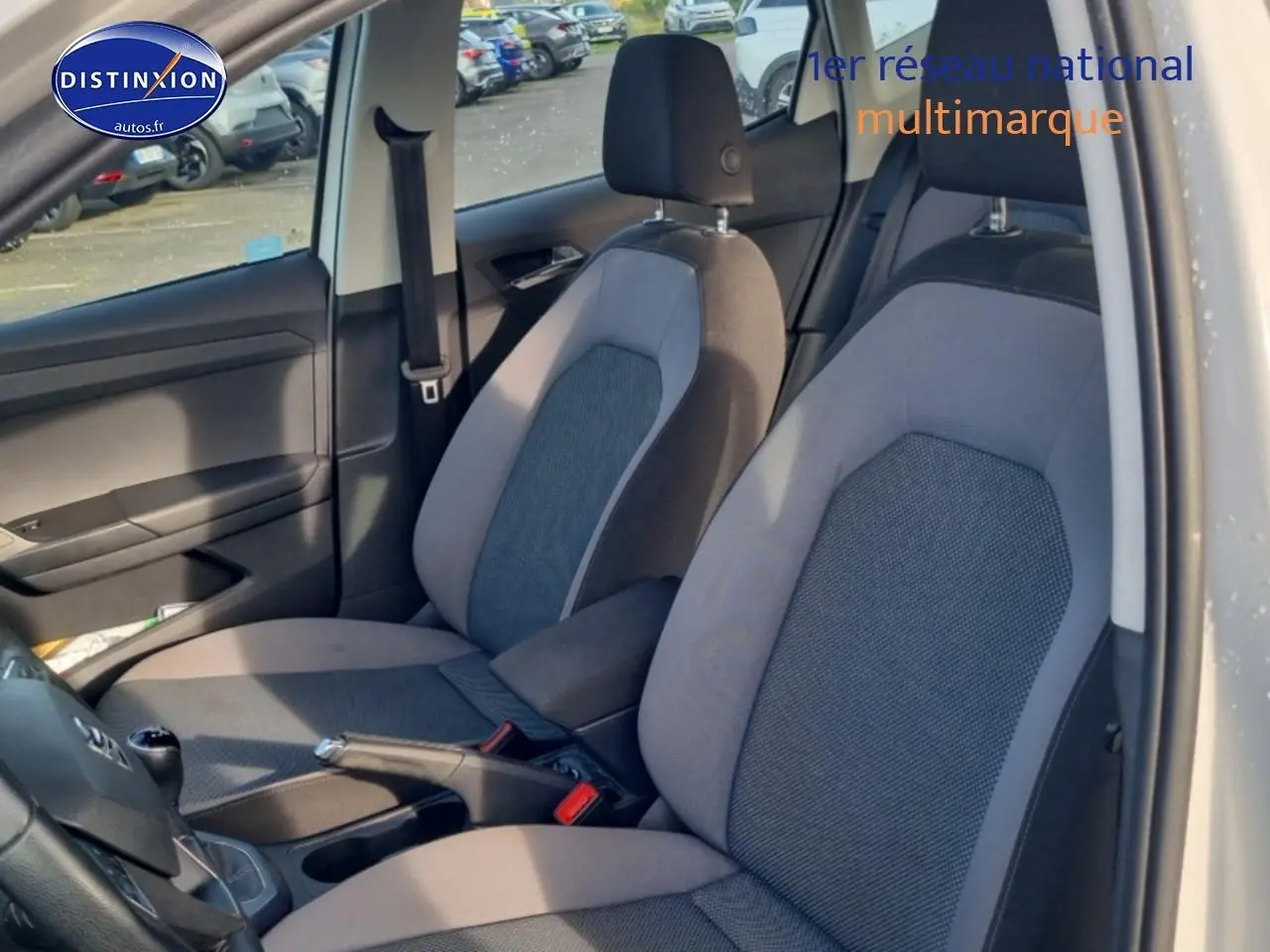 Vue intérieure côté conducteur du siège avant gris et noir d'une SEAT Arona 1.6 TDI 2019 avec levier de vitesse manuel en cuir.