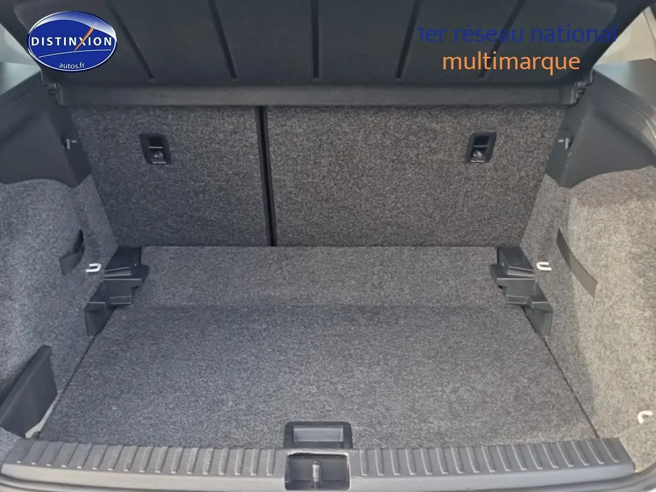 Coffre ouvert d'une SEAT Arona blanc 2019, vue intérieure montrant l'espace de chargement et la moquette grise.