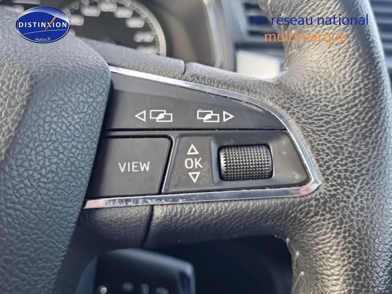 Gros plan sur les commandes multifonctions en cuir noir du volant d’un SEAT Arona blanc, version 2019.