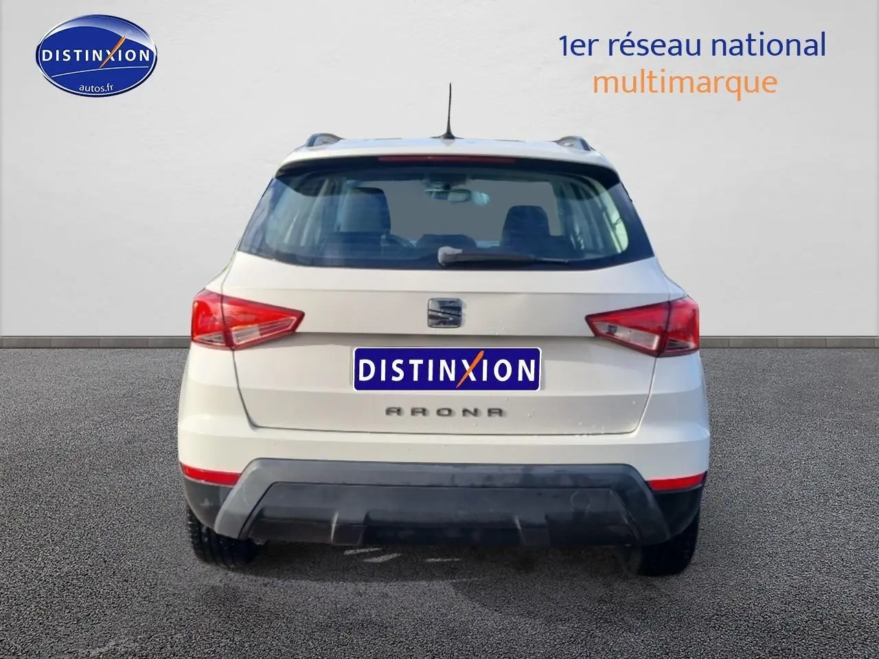 Vue arrière d'un SEAT Arona blanc de 2019 avec feux arrière LED et barres de toit visibles.