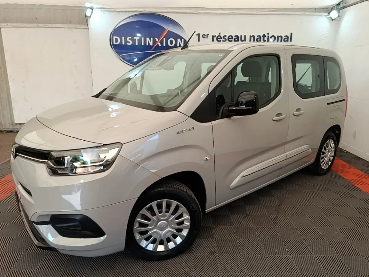 Toyota Proace City Verso électrique gris clair vu en 3/4 avant droit dans un showroom intérieur.