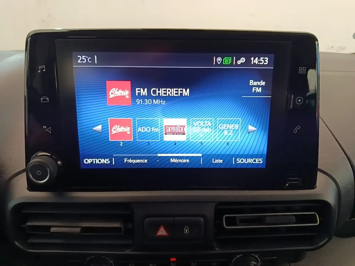 Écran tactile central du Toyota Proace City Verso électrique 2022 affichant les stations radio FM, entouré de commandes et aérateurs noirs.
