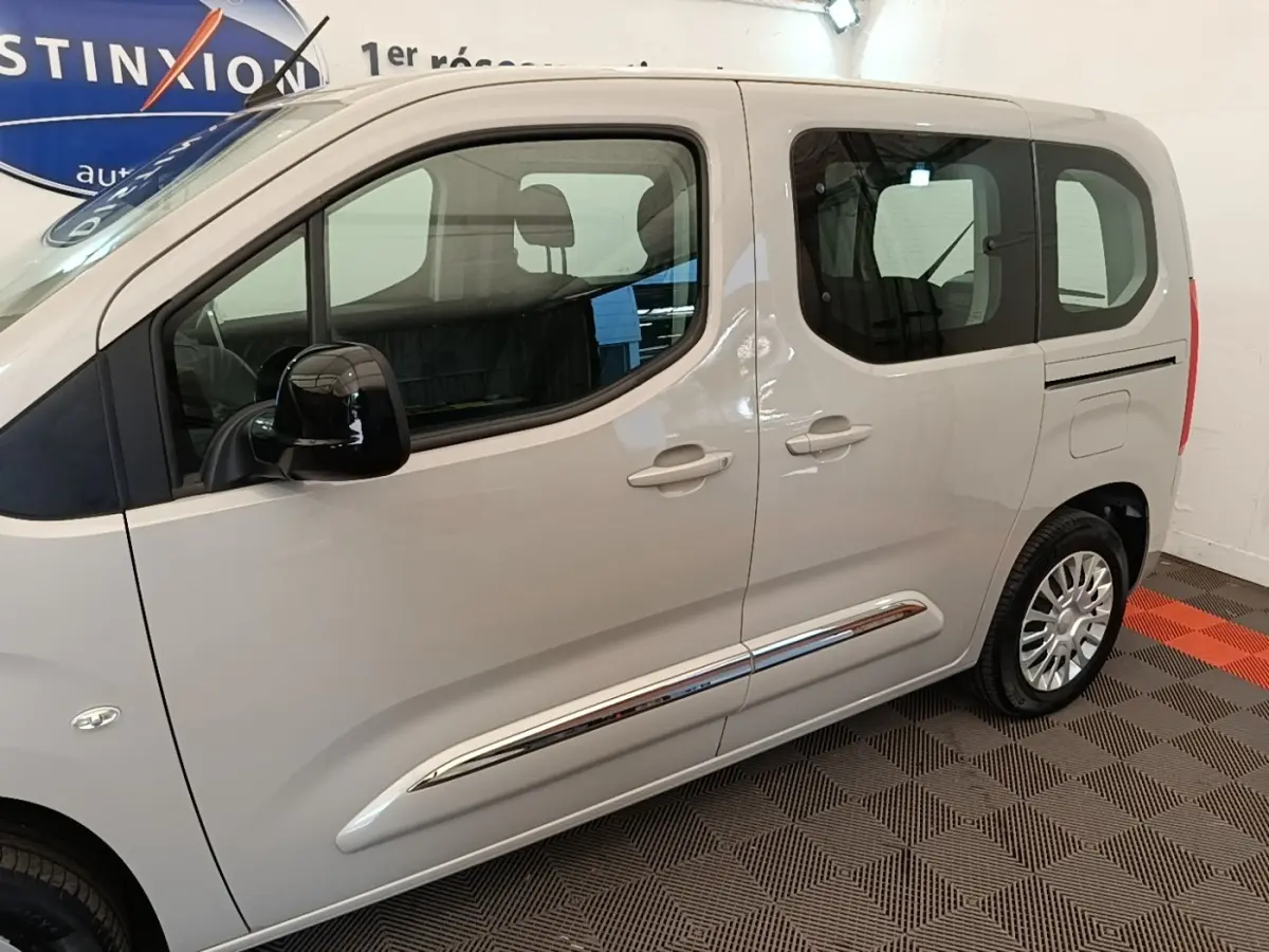 Vue latérale droite d'un Toyota Proace City Verso électrique gris clair avec jantes argentées et vitres teintées.