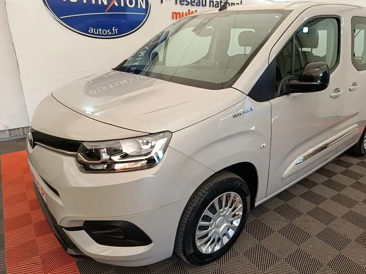 Vue 3/4 avant droit du Toyota Proace City Verso électrique gris clair, avec badge "Electric" visible sur l'aile avant.