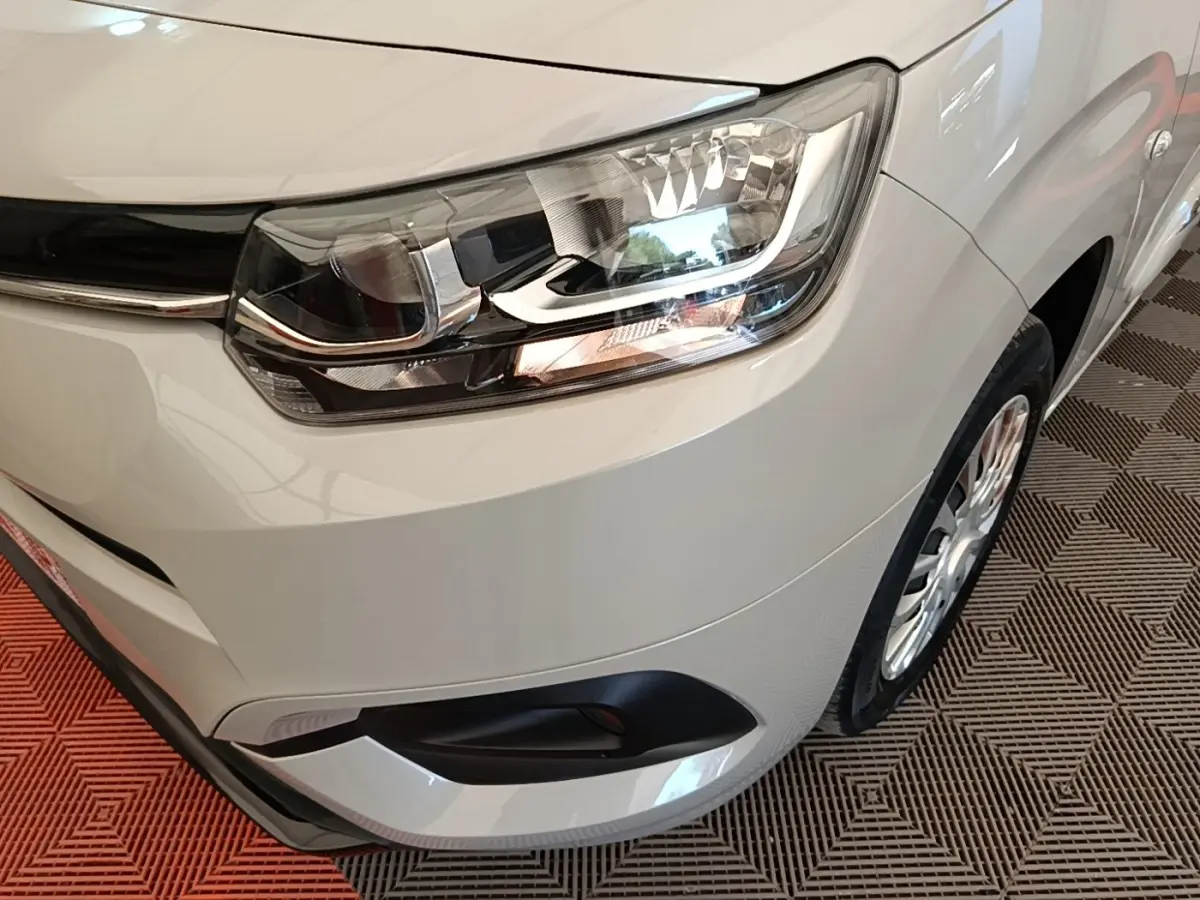 Gros plan sur l'avant droit gris clair du Toyota Proace City Verso Electric 2022, mettant en valeur le phare et la roue.